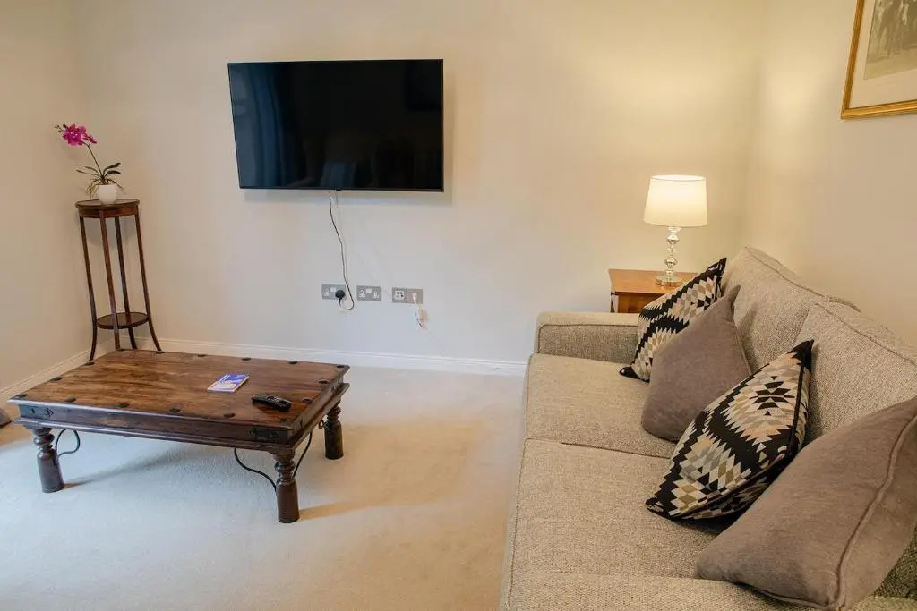 a living room with a couch and a coffee table at Hedgefield House - Serene Top Floor Flat in Inverness
