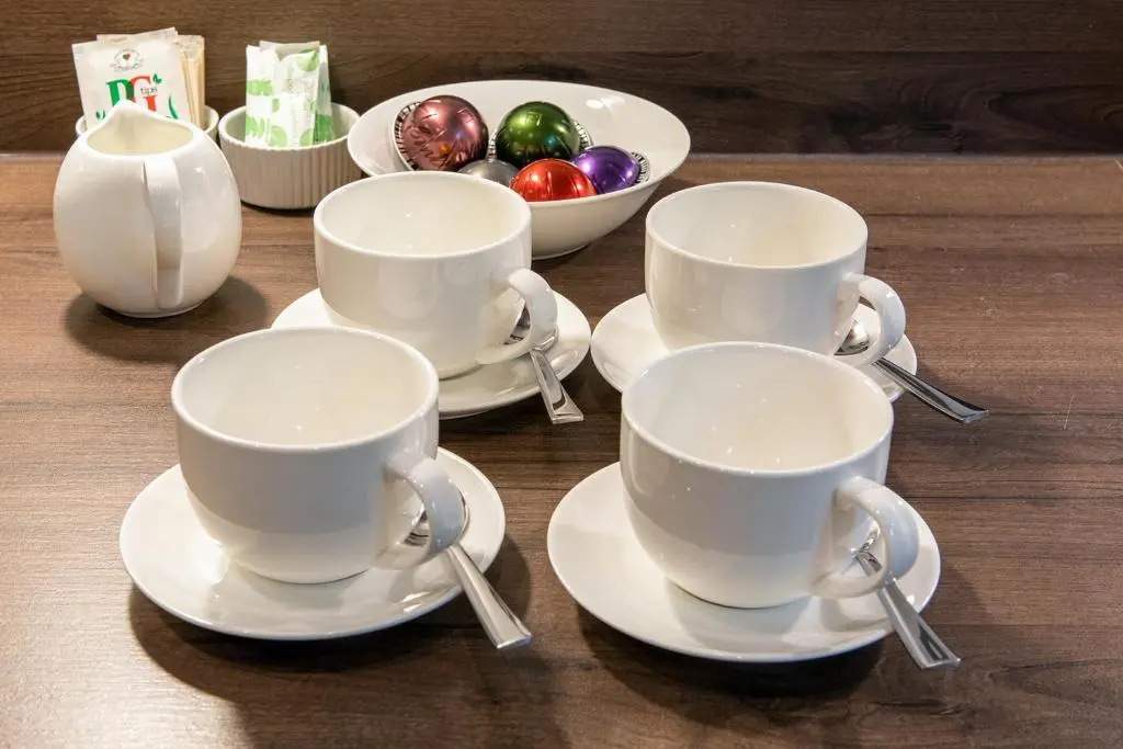 four cups and saucers on a table with christmas decorations at Hedgefield House - Serene Top Floor Flat in Inverness