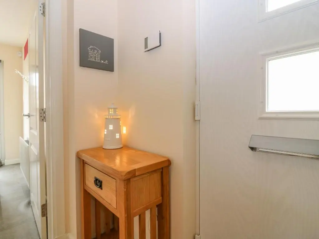 a small table with a light on it next to a door at 10 Goodhope Gardens in Aberdeen