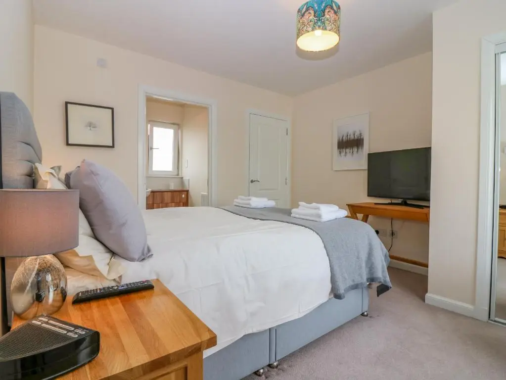 a bedroom with a bed with a desk and a television at 10 Goodhope Gardens in Aberdeen