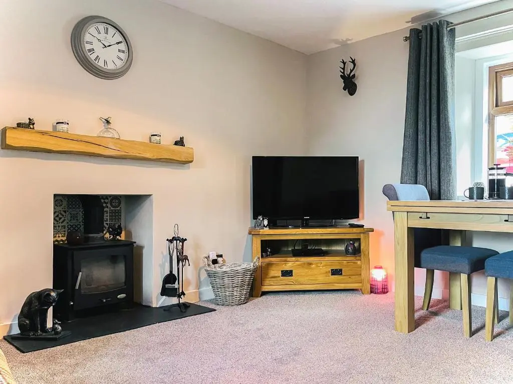 a living room with a television and a fireplace at Portknockie Escape in Portknockie