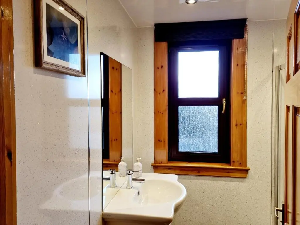 a bathroom with a sink and a window at Inverness City 3 bedroom house free parking in Inverness