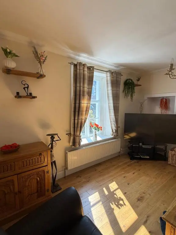 a living room with a flat screen tv and a window at Riverside Cottage City Centre in Inverness
