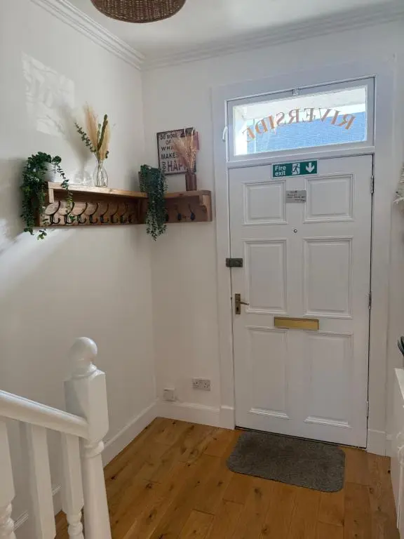 a white door with a sign on it in a room at Riverside Cottage City Centre in Inverness