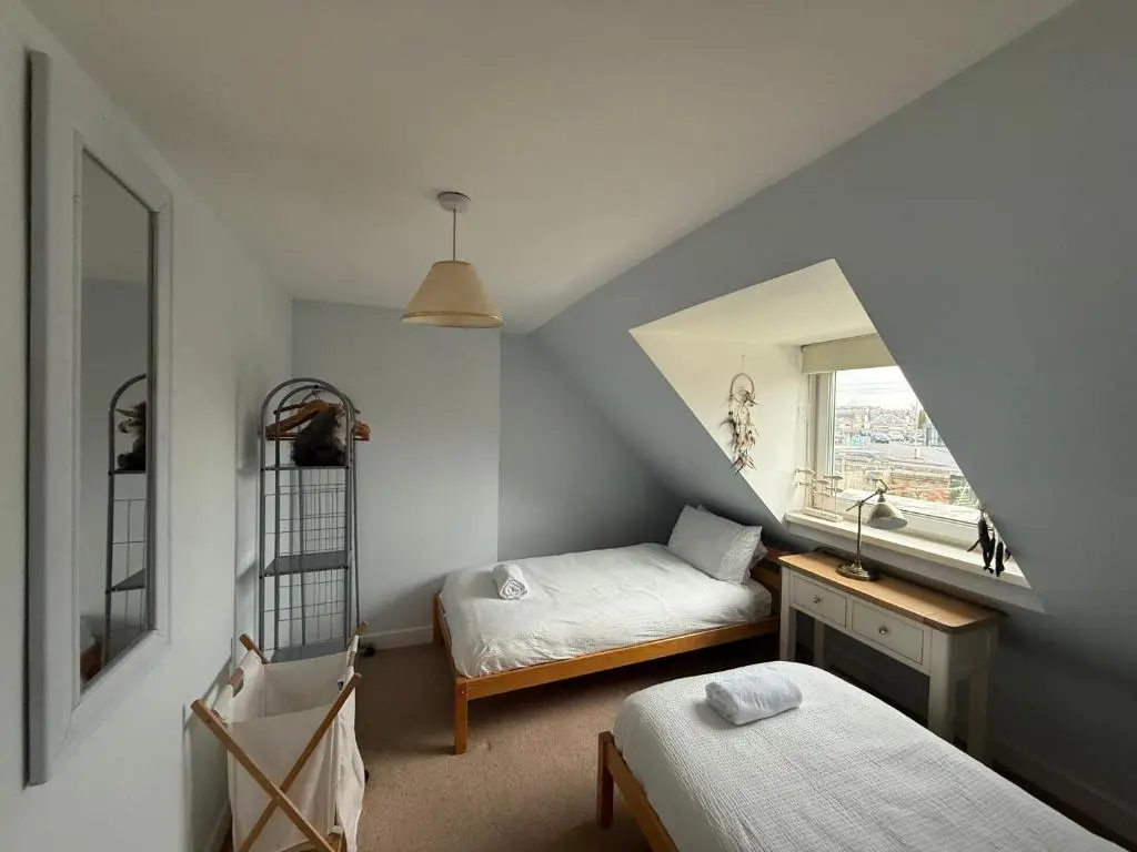 a attic room with two beds and a mirror at Riverside Cottage City Centre in Inverness