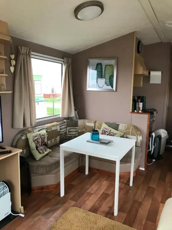 a living room with a white table and a couch at Melody Brooks Caravan Park in Portknockie