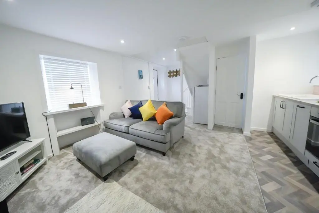 a living room with a couch and a television at The Wee House by the Sea in Balintore