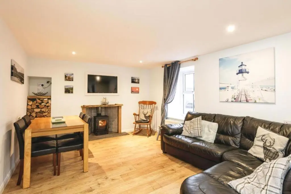 a living room with a leather couch and a table at 29 Seafield Street in Whitehills
