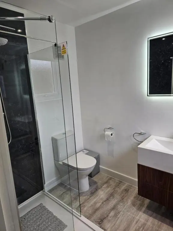 a bathroom with a toilet and a glass shower at Highland Retreats Cannich in Cannich