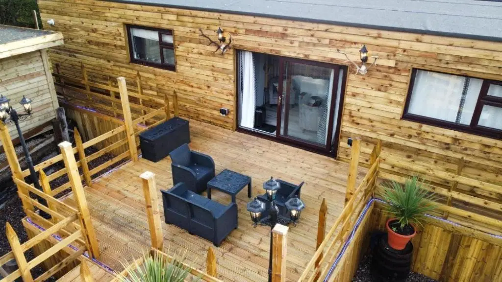 an aerial view of a wooden house with a deck at Highland Retreats Cannich in Cannich