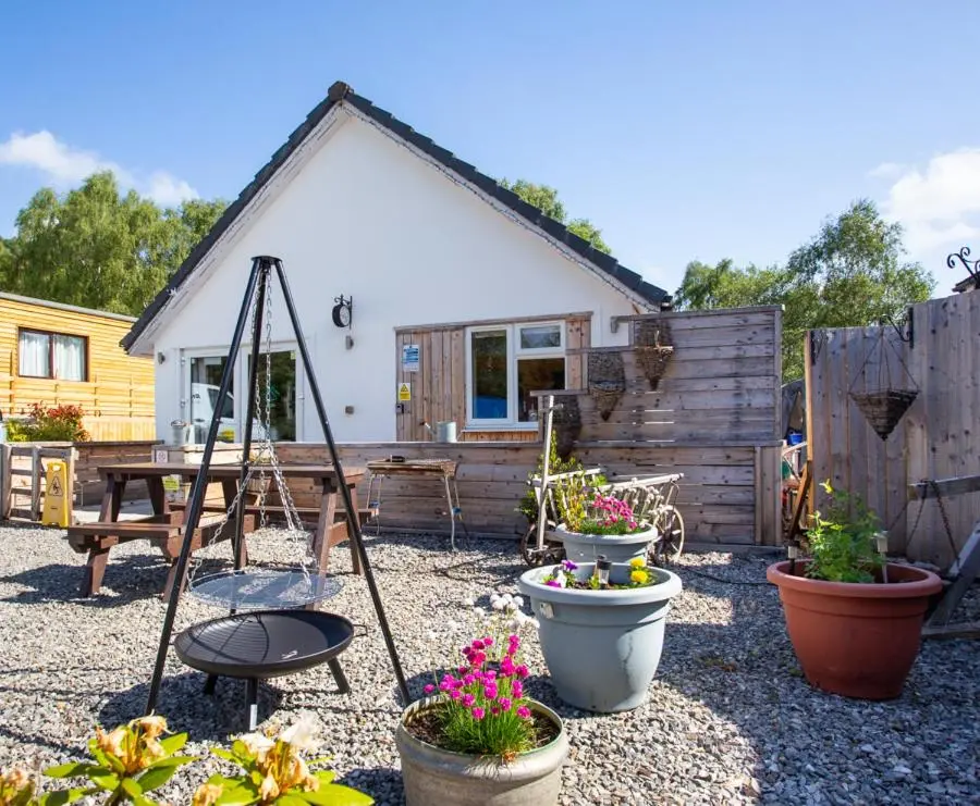 a garden with potted plants in front of a house at Highland Retreats Cannich in Cannich