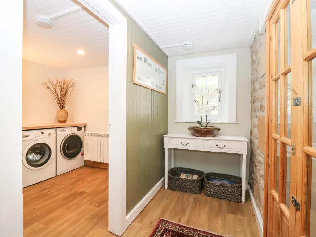 a laundry room with a washer and dryer at Garden Cottage in Elgin