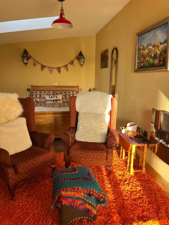 a living room with two chairs and a table at The Stable - NC500 in Wick