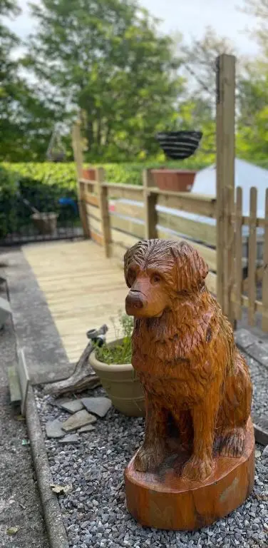 a statue of a dog sitting on the ground at Charleston Apartment Self Catering 5 min drive from town centre in Inverness