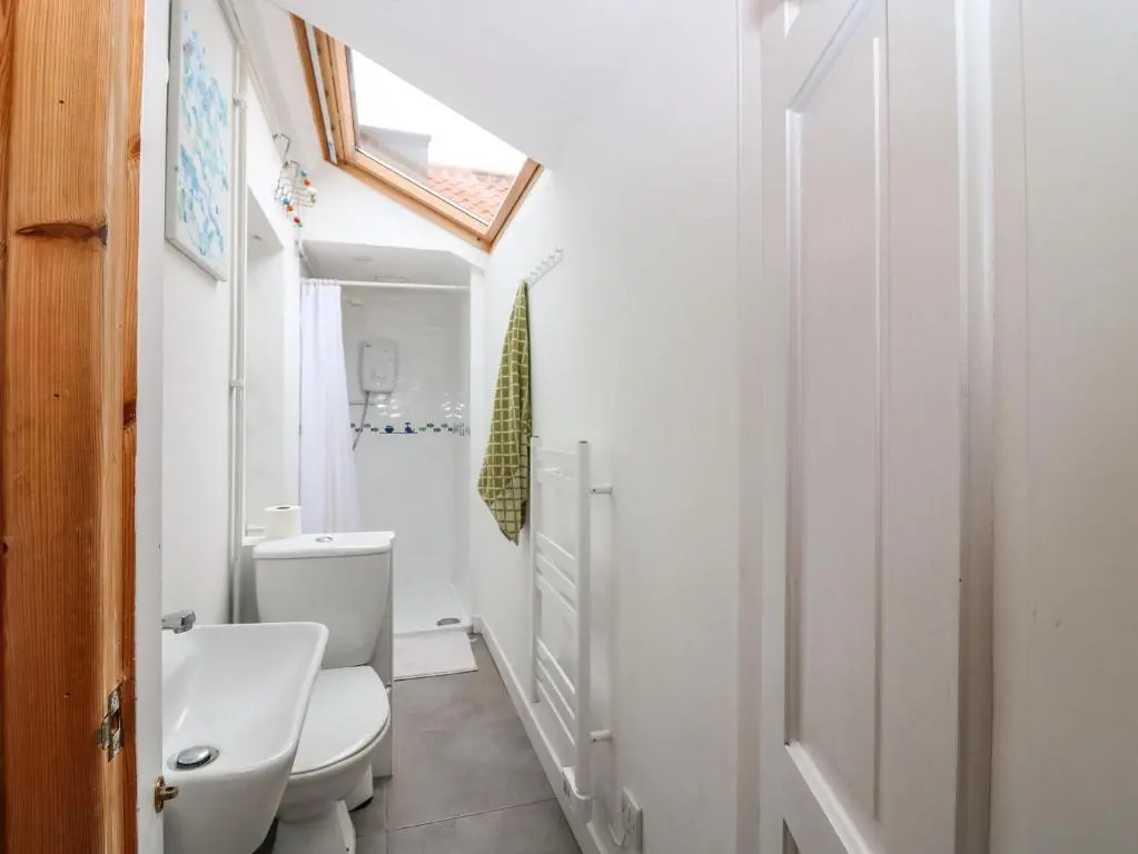 a bathroom with a white toilet and a sink at Dookers' Hoose in Buckie