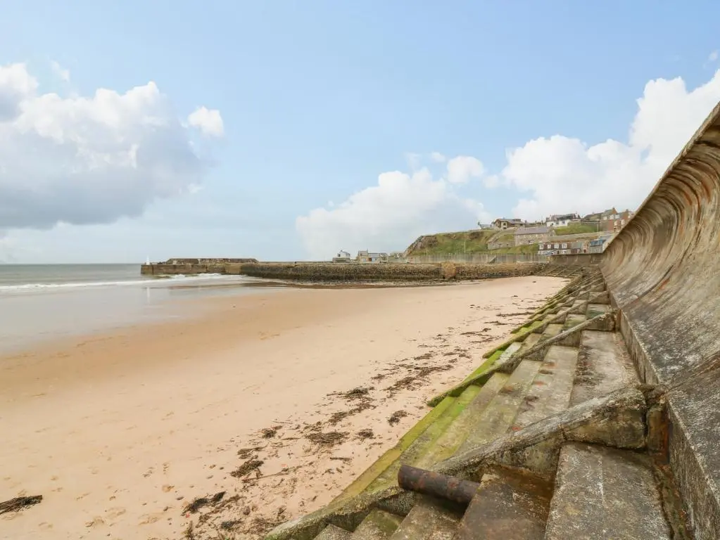 a view of a beach with a retaining wall at Dookers' Hoose in Buckie
