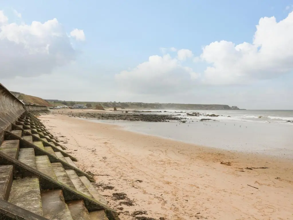 a view of a beach with a wooden fence at Dookers' Hoose in Buckie