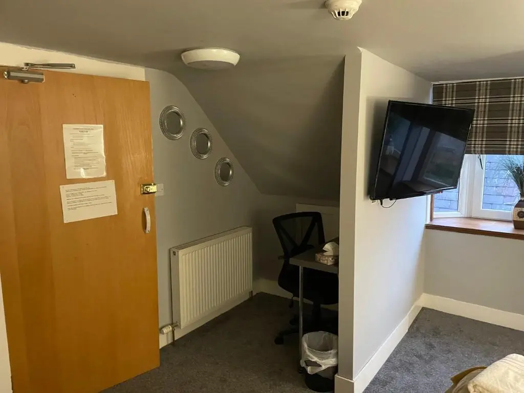a room with a door and a flat screen tv at Commercial Hotel (Insch) in Insch