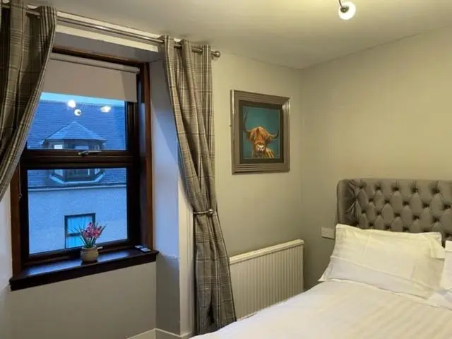a bedroom with a bed and a window at Commercial Hotel (Insch) in Insch