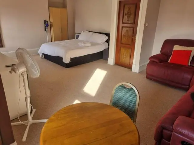 a bedroom with a bed and a table and a couch at Commercial Hotel (Insch) in Insch