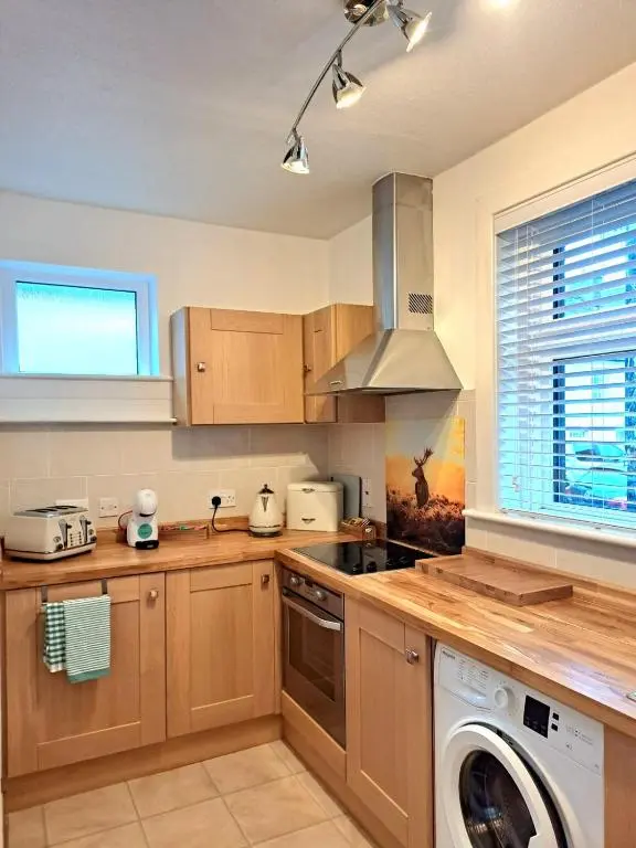 a kitchen with a washing machine and a washer at Old Tavern House in Fortrose