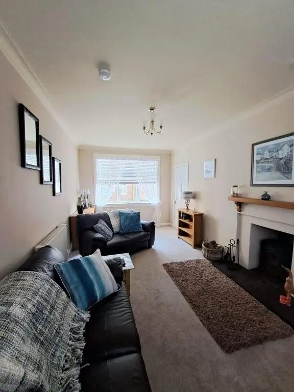 a living room with a couch and a fireplace at Old Tavern House in Fortrose