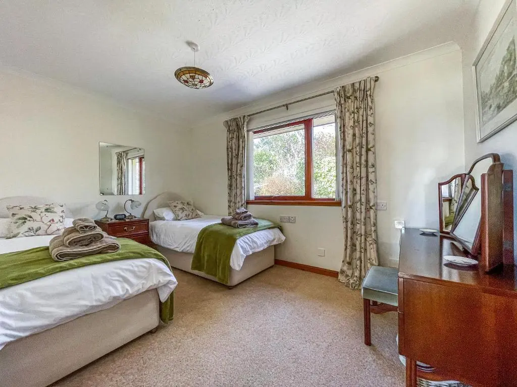 a bedroom with two beds and a window at Chanonry View Holiday Cottage in Fortrose