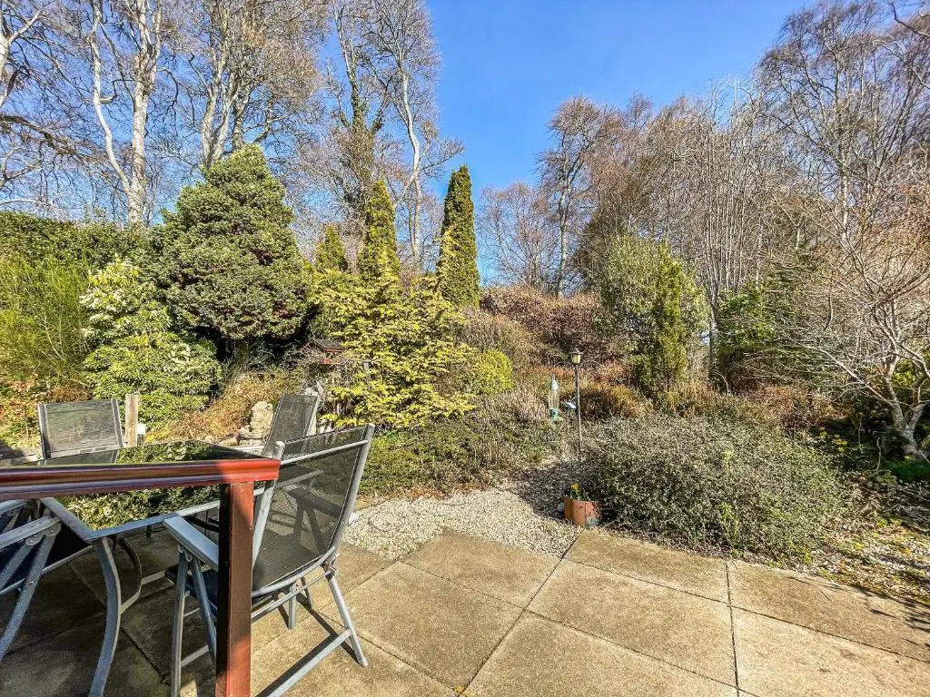 a patio with a table and chairs and trees at Chanonry View Holiday Cottage in Fortrose
