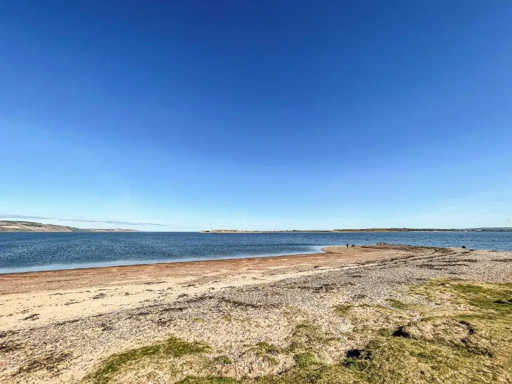 a sandy beach with the ocean in the background at Chanonry View Holiday Cottage in Fortrose