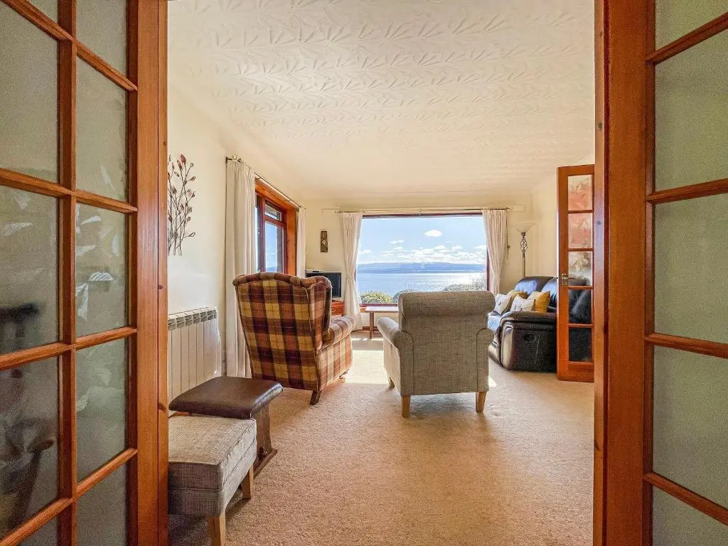 a living room with a view of the ocean at Chanonry View Holiday Cottage in Fortrose