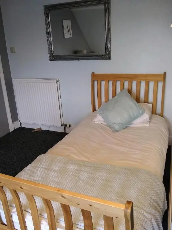 a bed in a bedroom with a mirror on the wall at White Horse Hotel in Strichen
