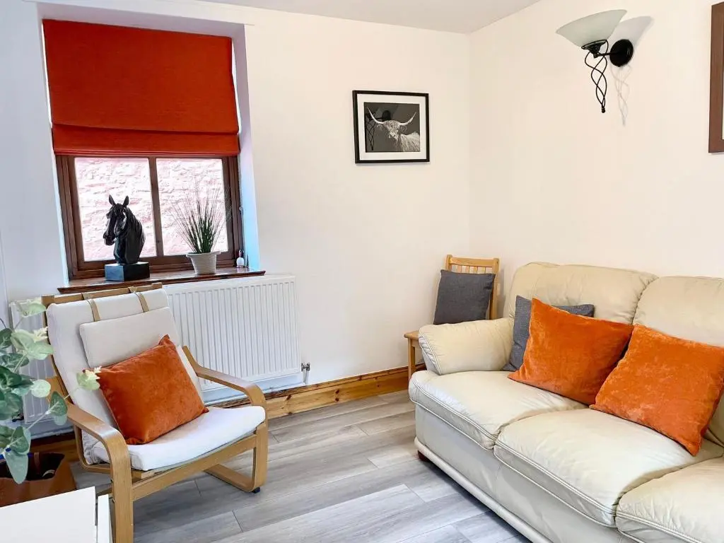 a living room with a couch and a chair at The Smiddy in Inverness