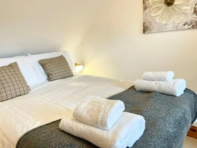 a bedroom with a bed with towels on it at The Smiddy in Inverness