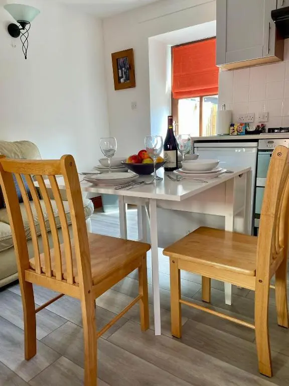 a kitchen with a table and chairs with wine glasses at The Smiddy in Inverness
