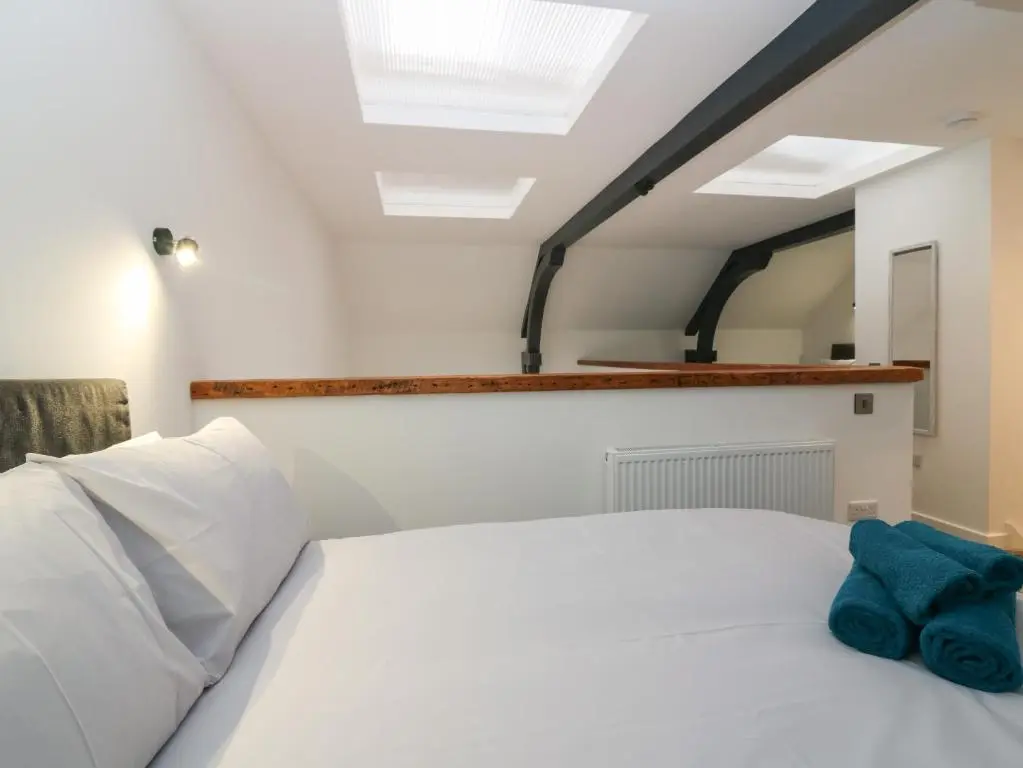 a bedroom with a white bed and a skylight at The Dance Hall, The Institute Executive Apartments in Keith