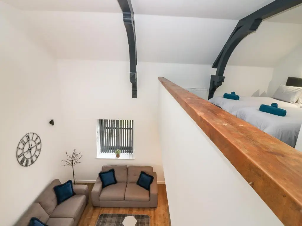 a loft bedroom with a bed and a couch at The Dance Hall, The Institute Executive Apartments in Keith