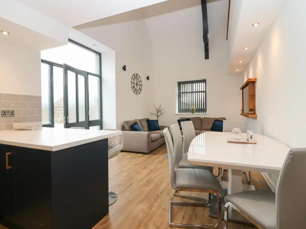a kitchen and living room with a table and chairs at The Dance Hall, The Institute Executive Apartments in Keith