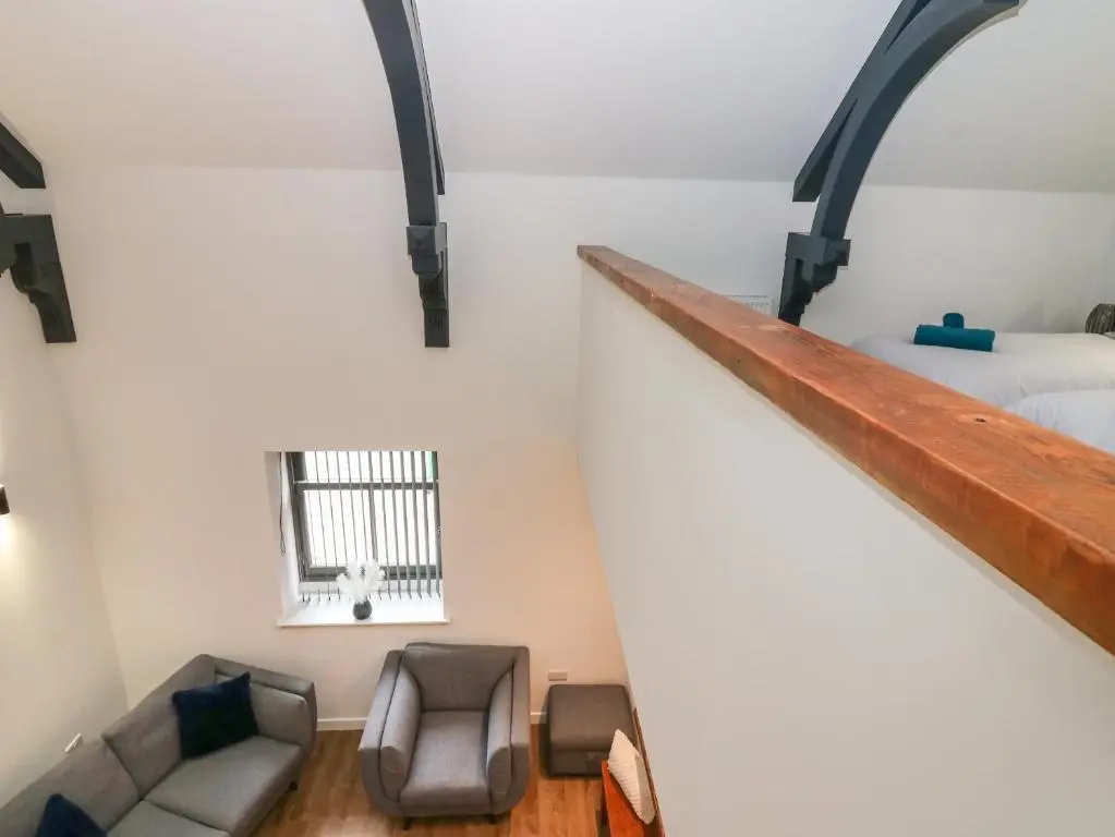 a loft bedroom with a bed and a couch at The Reception Room at The Institute Executive Apartments in Keith