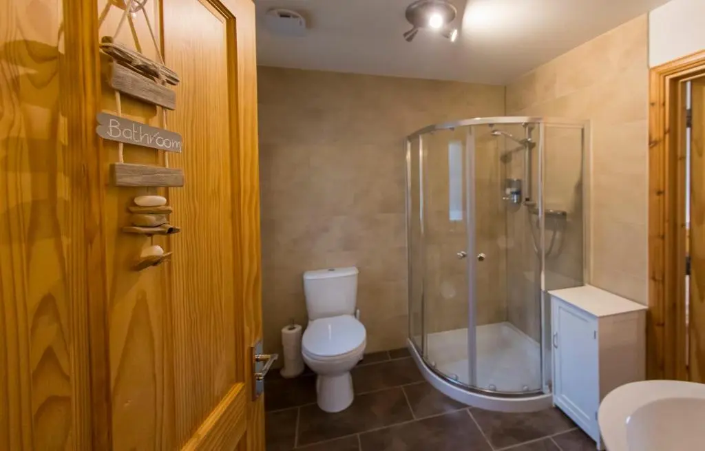 a bathroom with a toilet and a glass shower at Cuillich Mill Bed and Breakfast in the Highlands in Alness