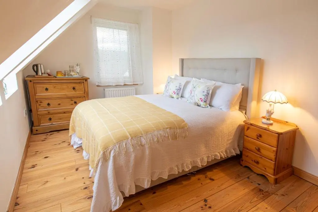 a bedroom with a bed and a dresser and a window at Cuillich Mill Bed and Breakfast in the Highlands in Alness