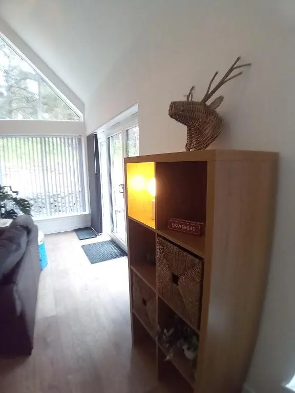 a living room with a tv on a wooden entertainment center at Sawmill Cottage in Grantown on Spey