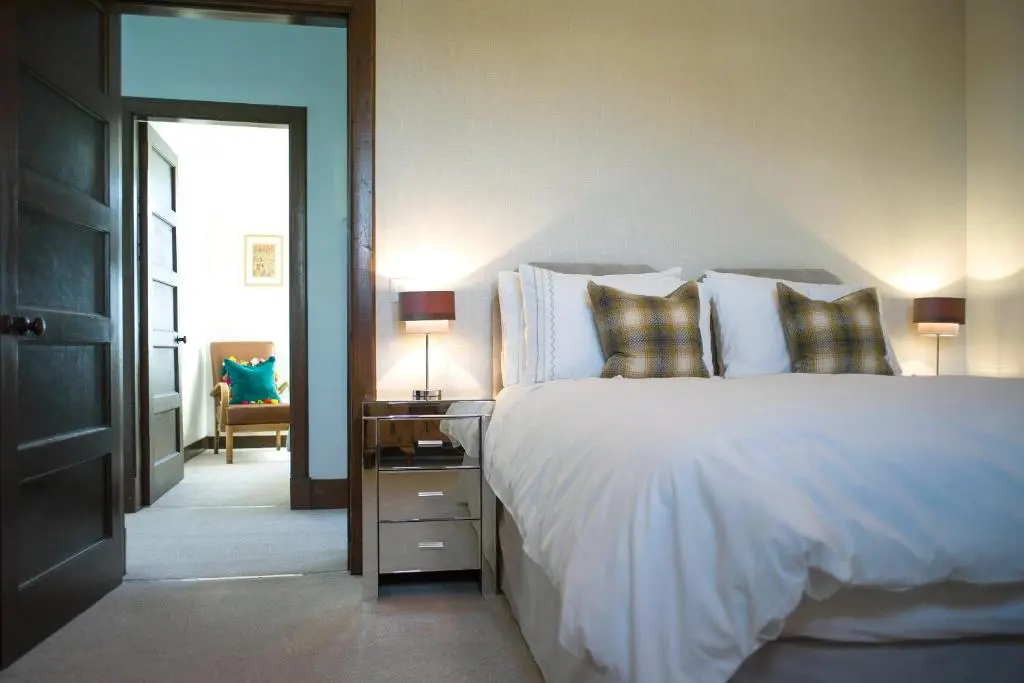 a bedroom with a bed and a table with a lamp at The Presbytery, Forres in Forres