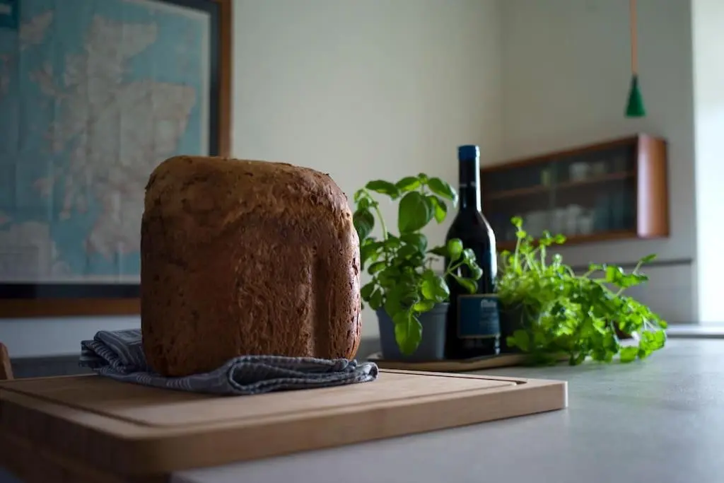 a cake sitting on a table with a bottle of wine at The Presbytery, Forres in Forres