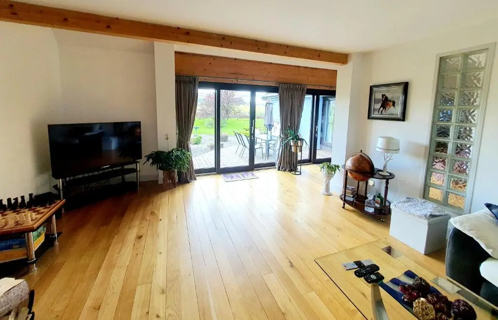 a living room with a flat screen tv and a wooden floor at Lindas Retreats Self catering accommodation 1 bedroom cottage or 3 bedroom House in Tomintoul