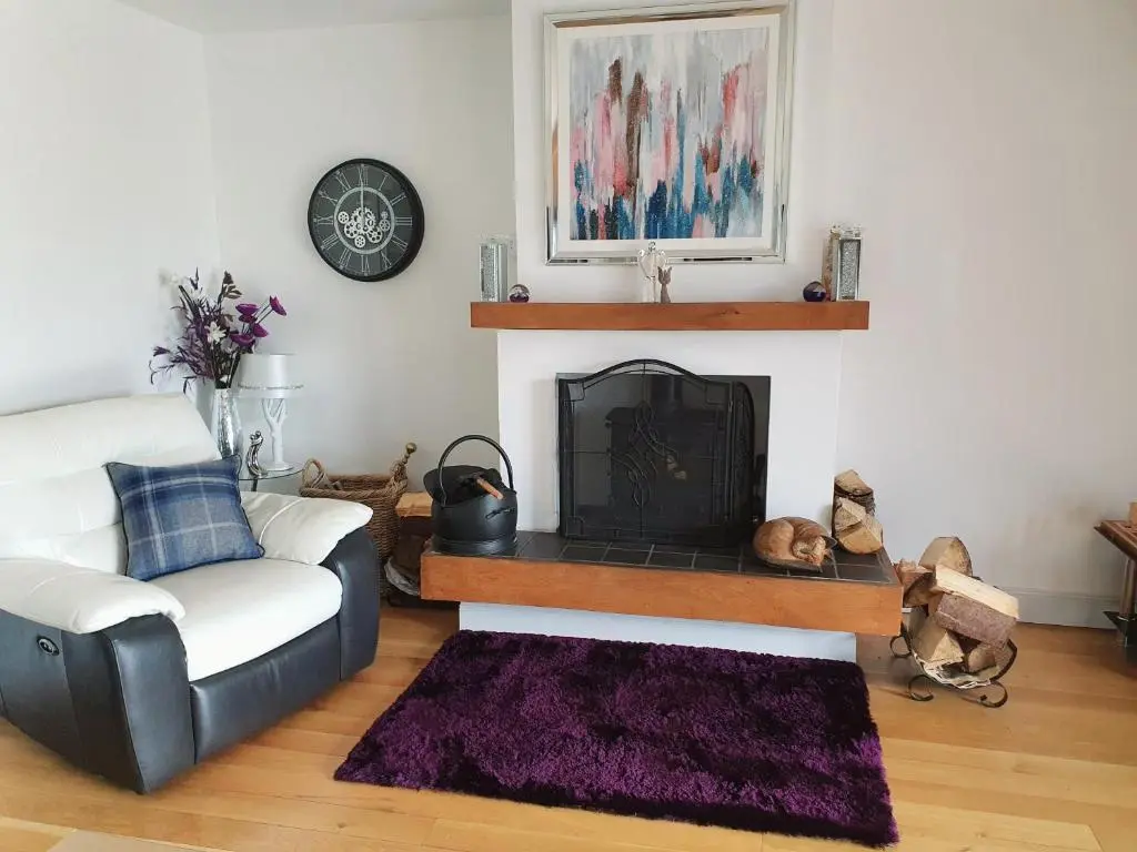 a living room with a couch and a fireplace at Lindas Retreats Self catering accommodation 1 bedroom cottage or 3 bedroom House in Tomintoul