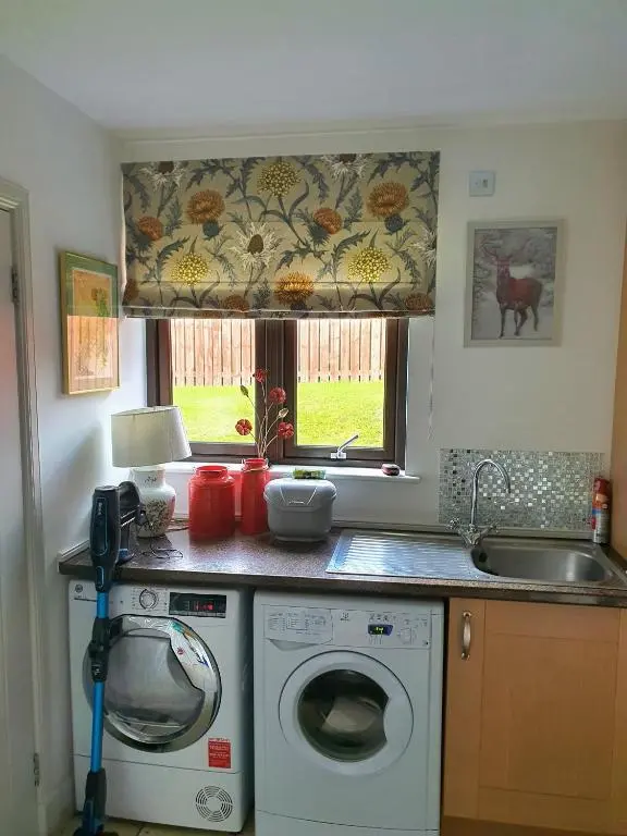 a kitchen with a washing machine and a sink at Lindas Retreats Self catering accommodation 1 bedroom cottage or 3 bedroom House in Tomintoul