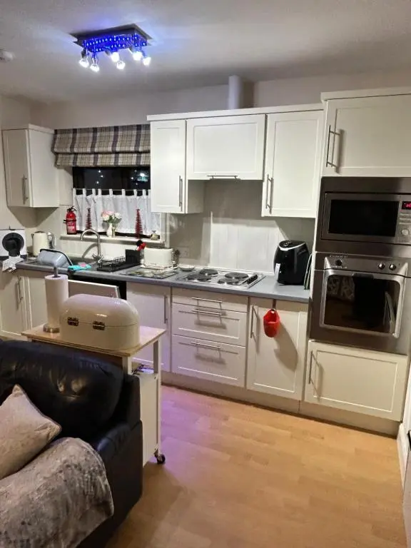 a kitchen with white cabinets and a stove top oven at Lindas Retreats Self catering accommodation 1 bedroom cottage or 3 bedroom House in Tomintoul