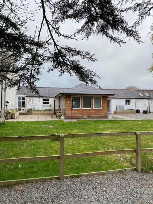 a wooden fence in front of a house at Cosy Cottage in beautiful Royal Deeside in Aboyne