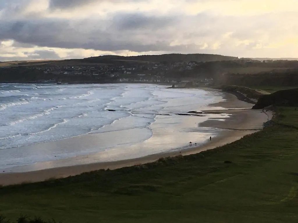 a view of a beach with people walking on the sand at Zen Cottage Cullen - Sleeps 4 Garden & Pets Ok in Cullen