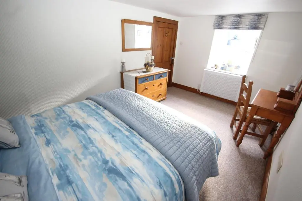 a bedroom with a bed and a desk and a window at Zen Cottage Cullen - Sleeps 4 Garden & Pets Ok in Cullen